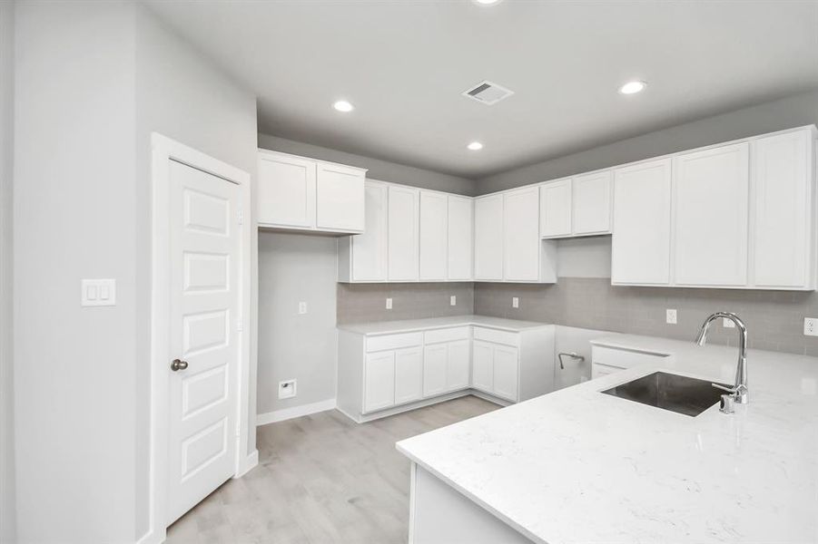 Discover another perspective of this beautiful kitchen with a walk-in pantry.