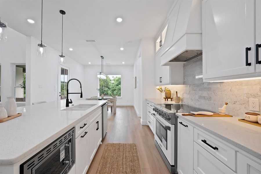 Modern kitchen featuring white cabinetry, light-colored countertops, and wood-finish flooring