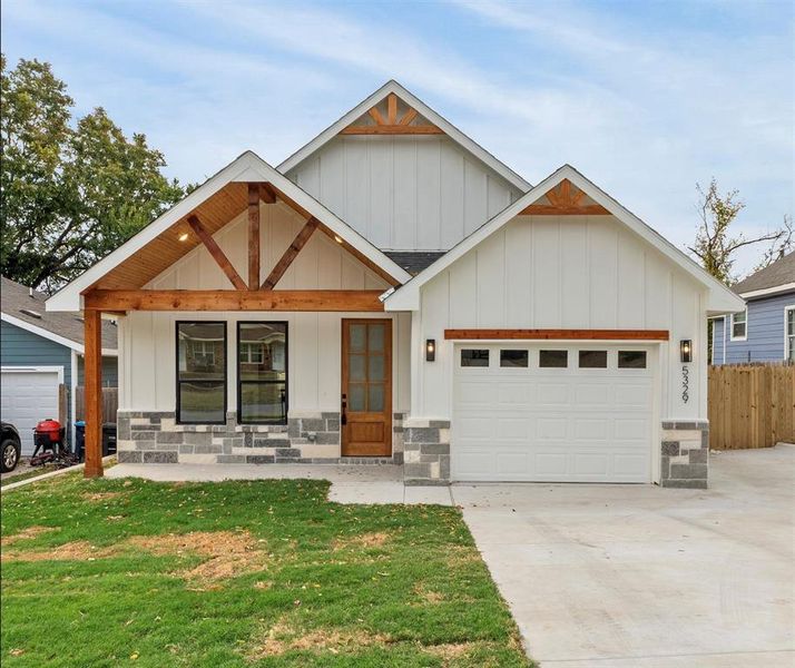 View of front facade featuring a garage and a front lawn