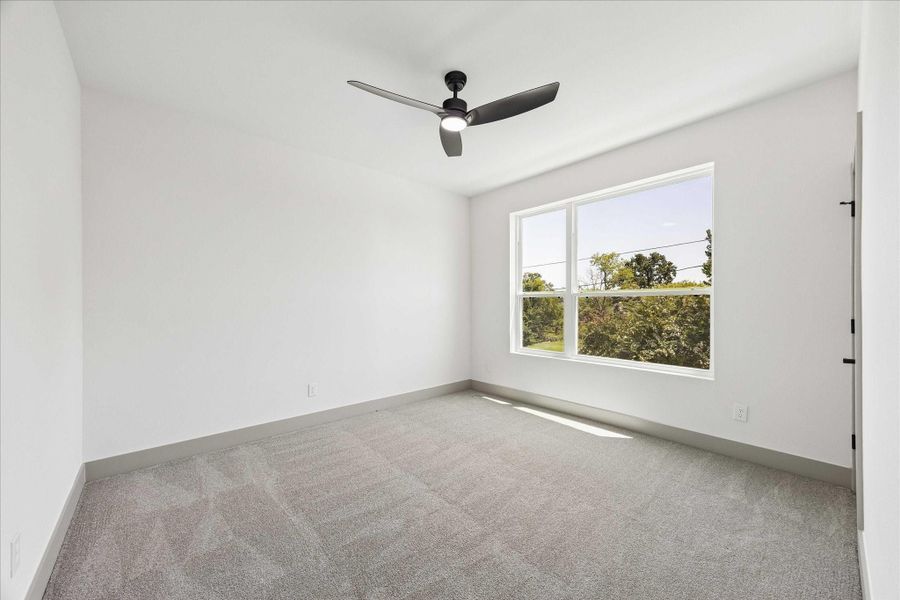 Privately tucked away on the main living level, this secondary bedroom offers flexibility as a guest suite, home office, or comfortable everyday bedroom.