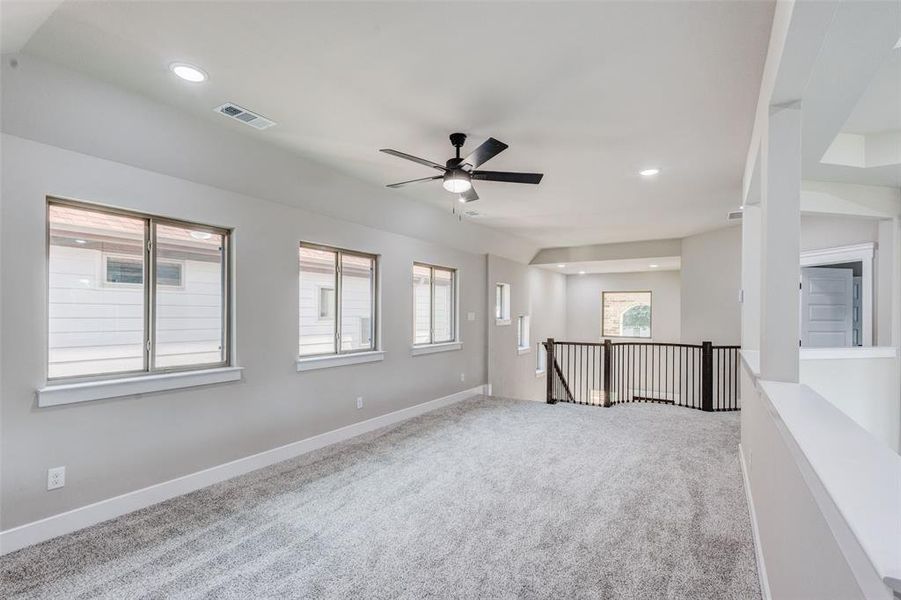 Carpeted loft with recessed lighting and a ceiling fan