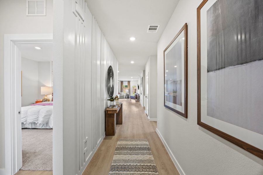 A hallway with a bed and a mirror. A hallway with a bed and a mirror.