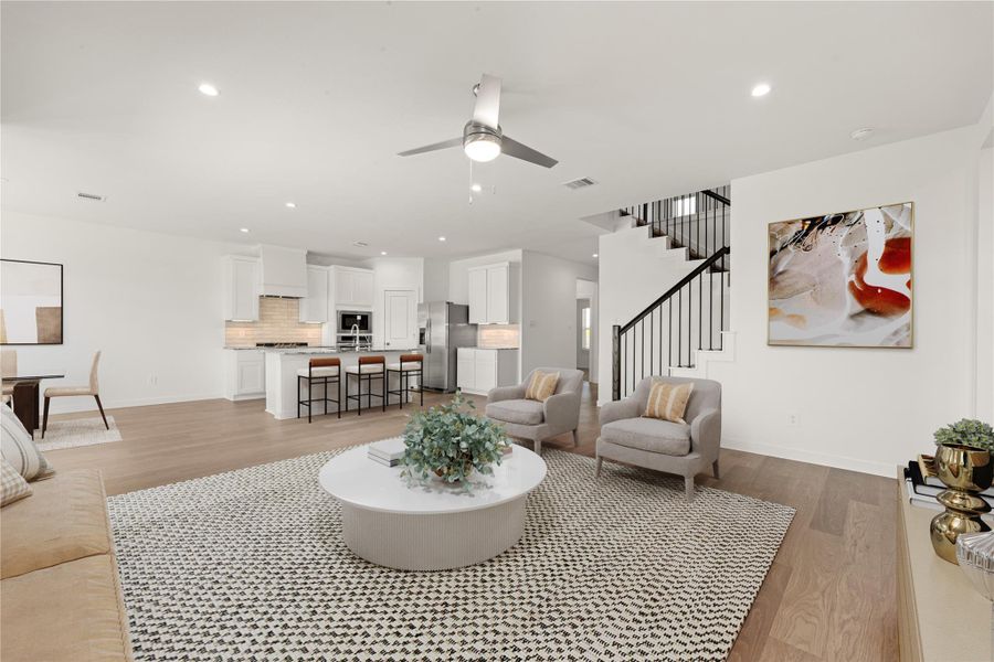 Discover the heart of the home in this bright and airy open-concept living space. Seamlessly connecting the spacious family room to a modern chef's kitchen featuring white cabinetry and a large island, this area is perfect for entertaining and everyday living. The elegant hardwood floors and contemporary design elements create an inviting atmosphere that you won't want to leave! *Virtually Staged