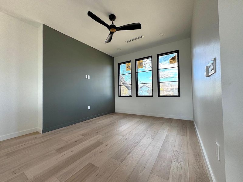 Unfurnished room featuring light wood-type flooring, baseboards, visible vents, and ceiling fan