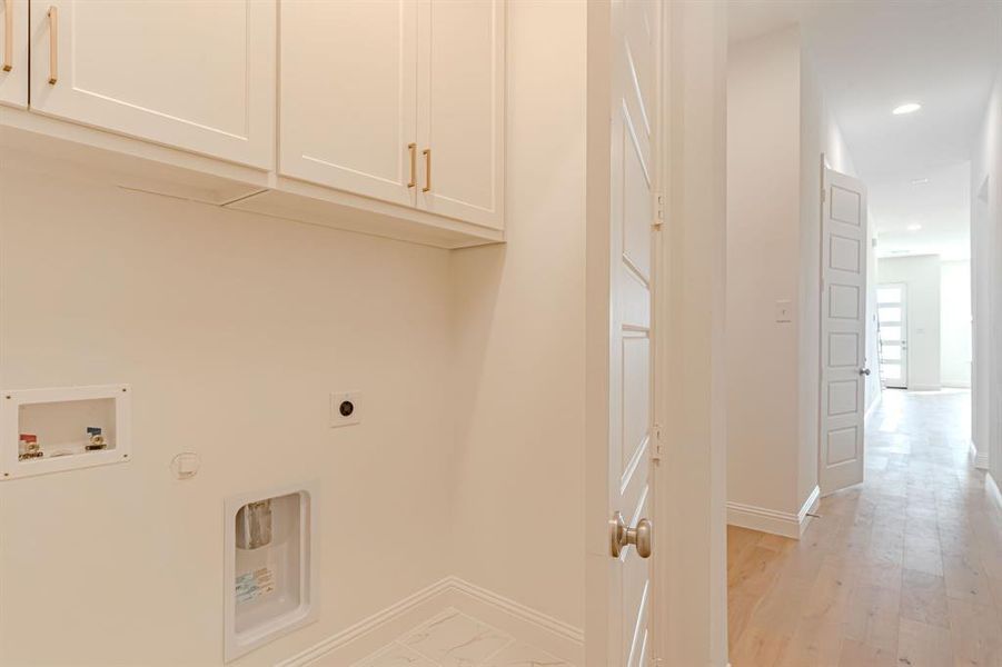 Full size washer dryer area with storage above