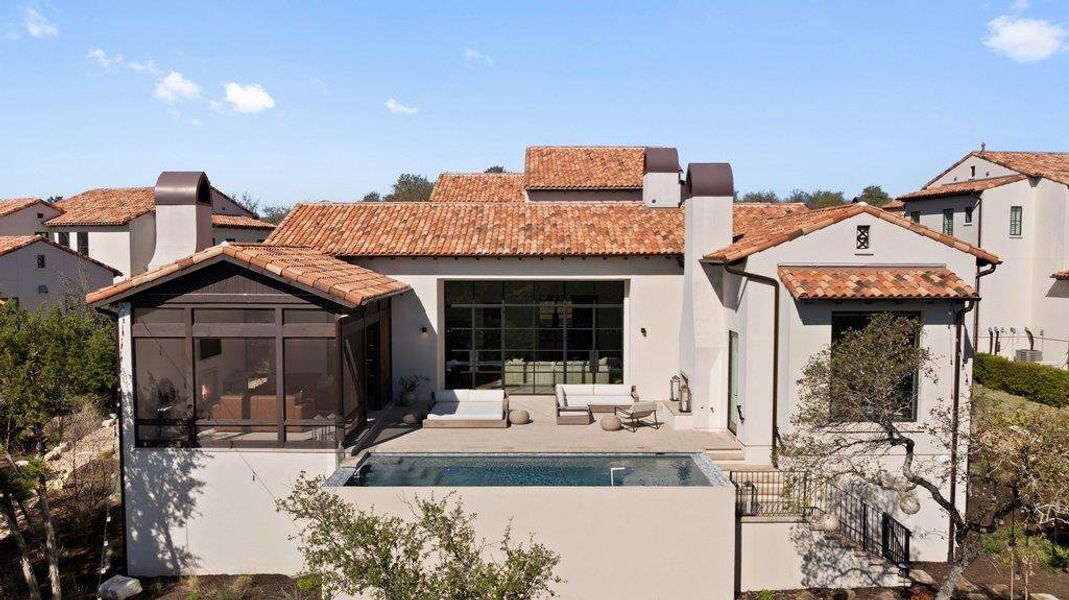 Rear view of house featuring an outdoor pool, a tile roof, and stucco siding