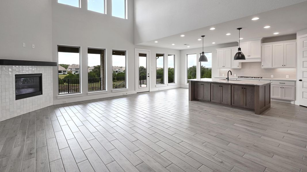 Kitchen featuring open floor plan, light countertops, white cabinetry, backsplash, and a towering ceiling Kitchen featuring open floor plan, light countertops, white cabinetry, backsplash, and a towering ceiling