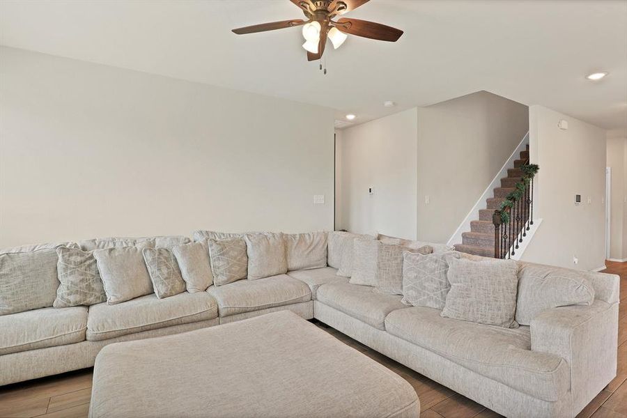 Living room with ceiling fan and hardwood / wood-style floors