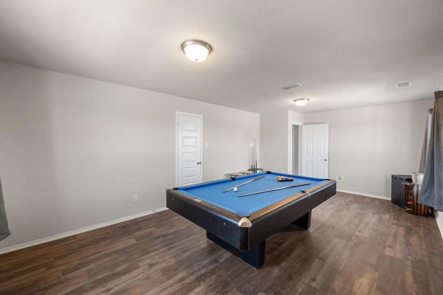 Game room with dark hardwood / wood-style flooring and pool table