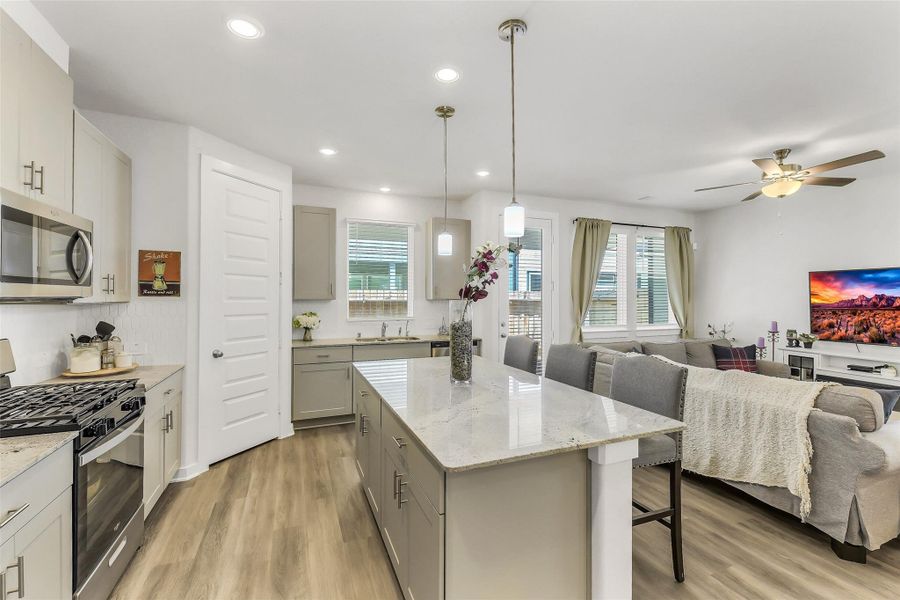 Contemporary kitchen with modern finishes, pendant lighting, spacious prep areas, and an oversized island ideal for casual dining and hosting guests.