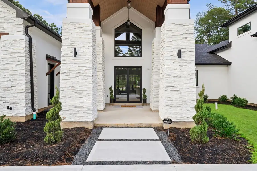 Dramatic covered entry featuring vaulted wood ceilings and custom stone columns.