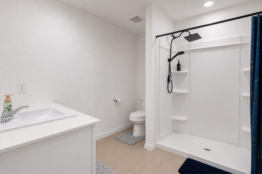 Bright primary bath featuring an oversized vanity, spacious walk-in shower, and direct access to the walk-in closet.