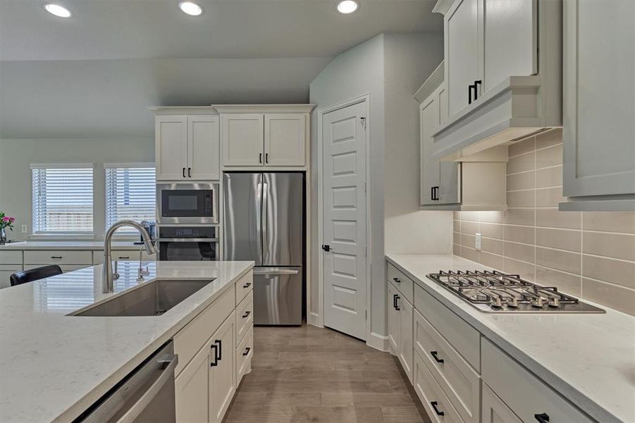 Gleaming stainless appliances including gas cooktop. Oversized single basin undercount sink with pull-down faucet is a bonus!  Don't miss the walk-in pantry!