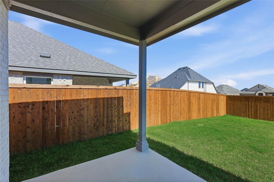 Fenced backyard with a patio