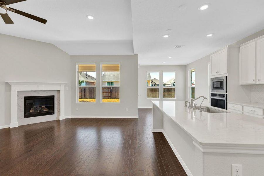 Kitchen featuring open floor plan, white cabinetry, stainless steel appliances, dark wood-type flooring, and recessed lighting Kitchen featuring open floor plan, white cabinetry, stainless steel appliances, dark wood-type flooring, and recessed lighting