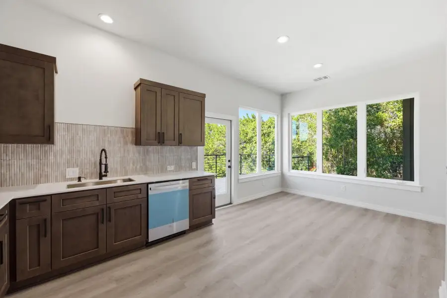 Kitchen with dark brown cabinetry, recessed lighting, dishwasher, backsplash, and light wood finished floors