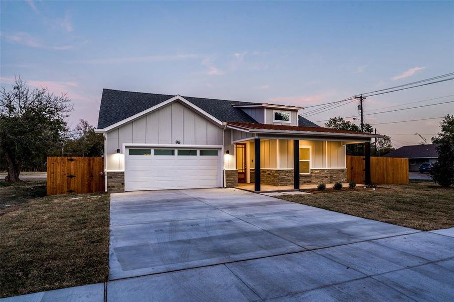 View of front of home featuring a garage and a lawn