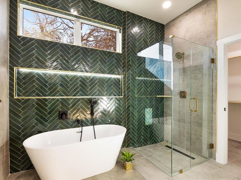 Full bath featuring tile patterned flooring, a freestanding tub, and a stall shower