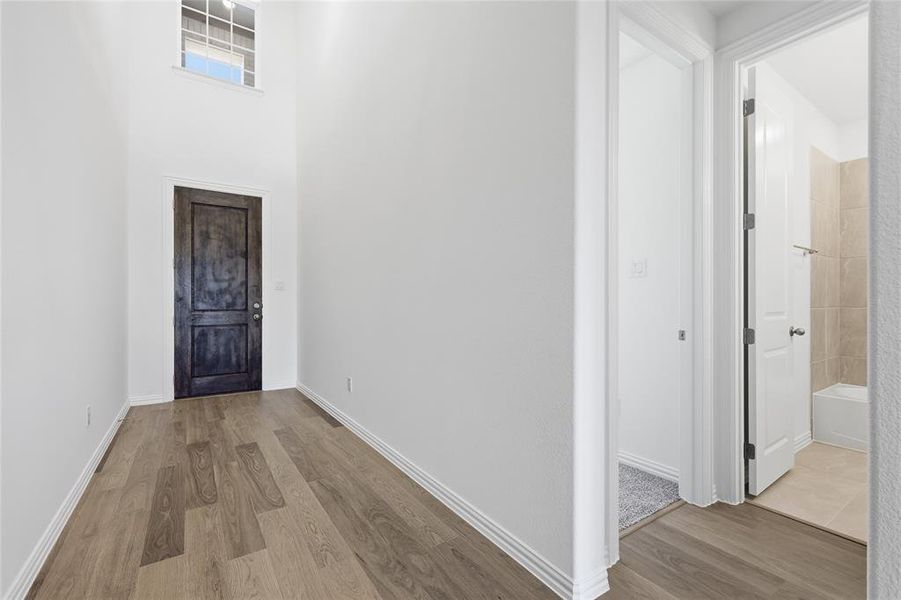 Hallway featuring wood finished floors and a high ceiling