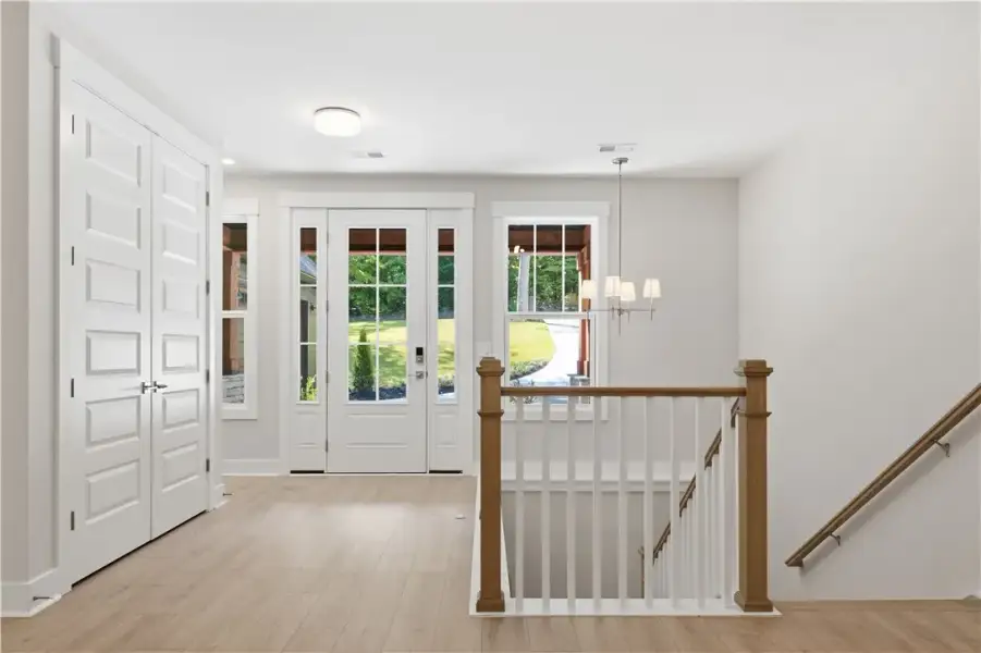 A welcoming entryway features handsome wood floori