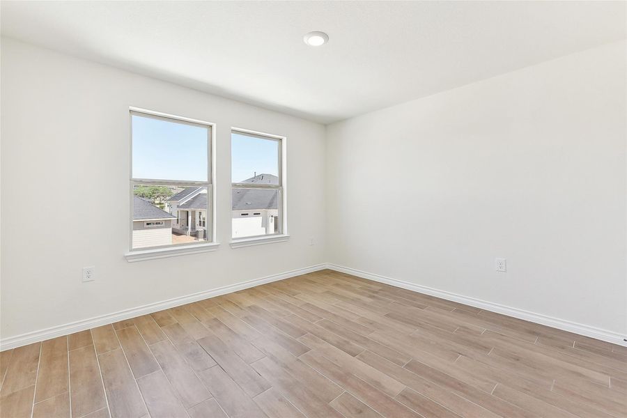 Spare room with light wood-style floors and baseboards Spare room with light wood-style floors and baseboards