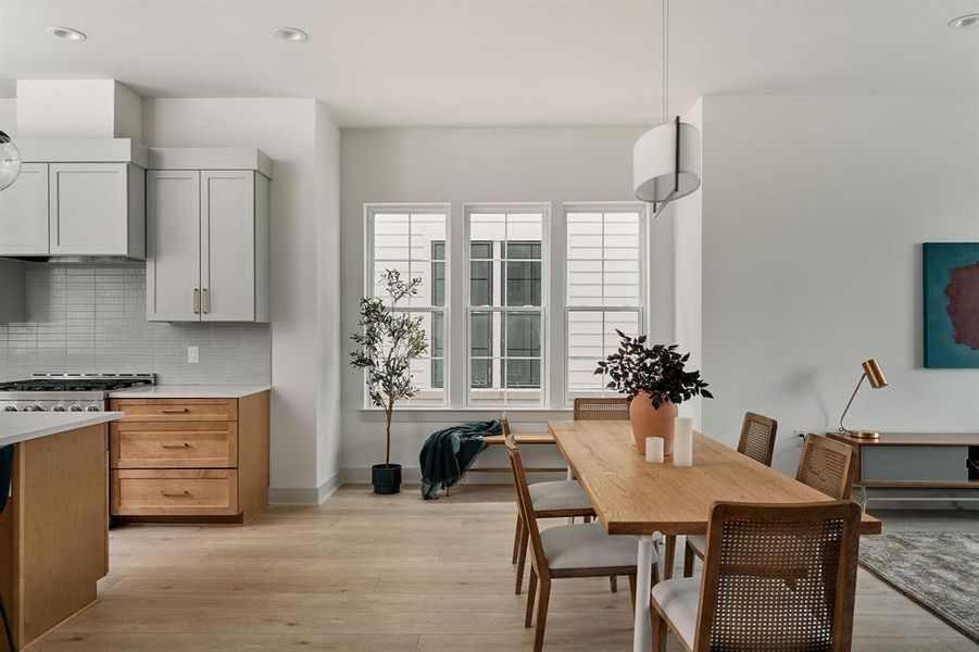 Open-concept living space featuring light wood-finish flooring, recessed lighting, and a modern drum pendant light fixture Open-concept living space featuring light wood-finish flooring, recessed lighting, and a modern drum pendant light fixture