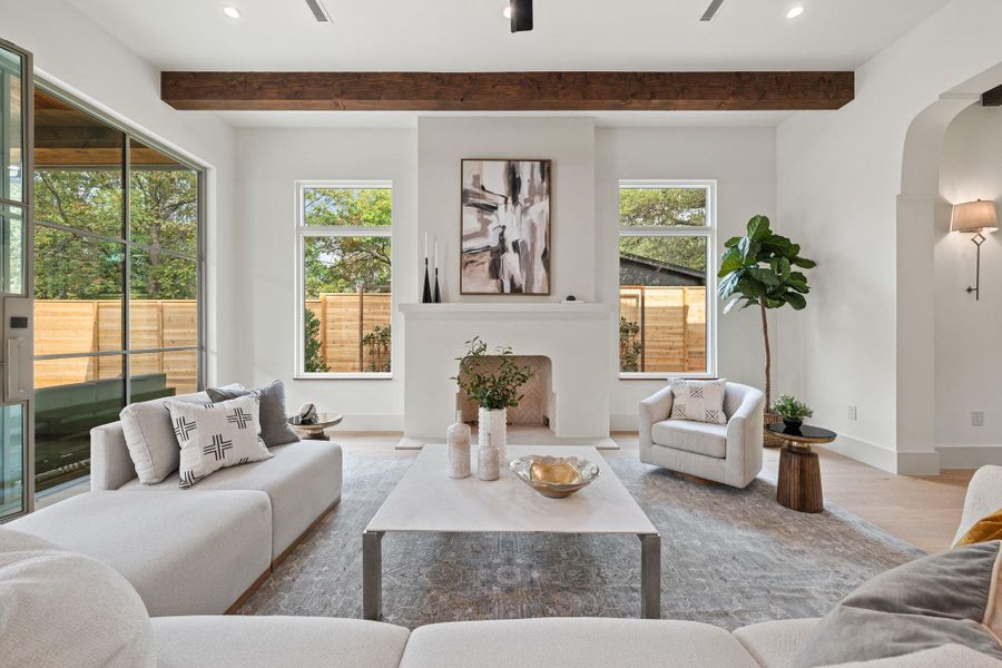 Living area with arched walkways, wood finished floors, a ceiling fan, beamed ceiling, and recessed lighting Living area with arched walkways, wood finished floors, a ceiling fan, beamed ceiling, and recessed lighting