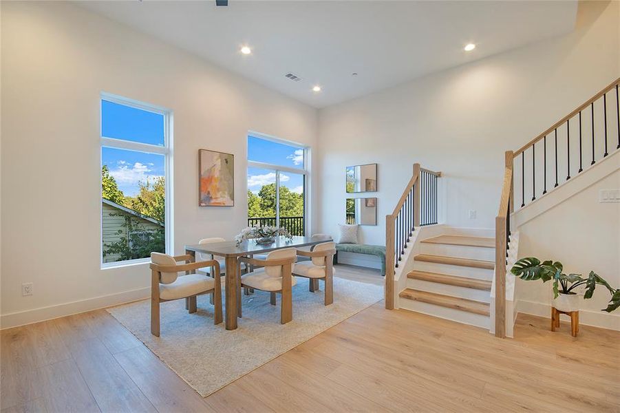 Dining space featuring light wood-style floors, recessed lighting, and stairs Dining space featuring light wood-style floors, recessed lighting, and stairs