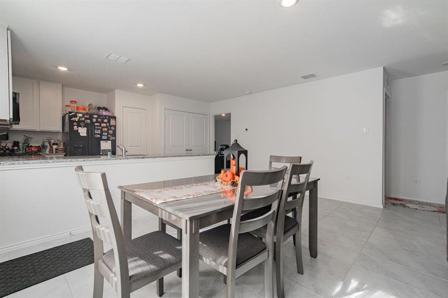 Dining area with light tile patterned floors and recessed lighting