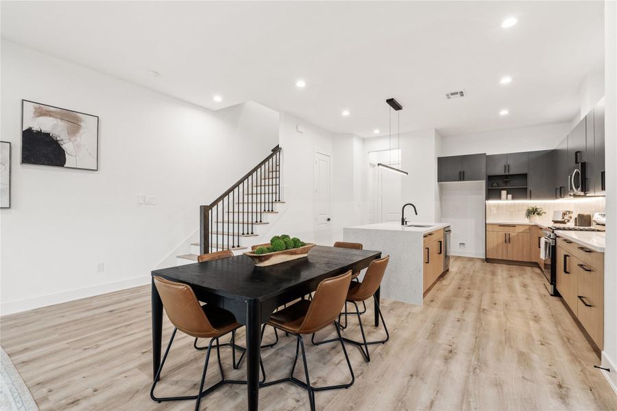 An elegant composition of craftsmanship and flow — oak-colored floors ground the open layout while clean-lined railings and recessed lighting emphasize Nima Homes’ signature blend of functionality and architectural intention.