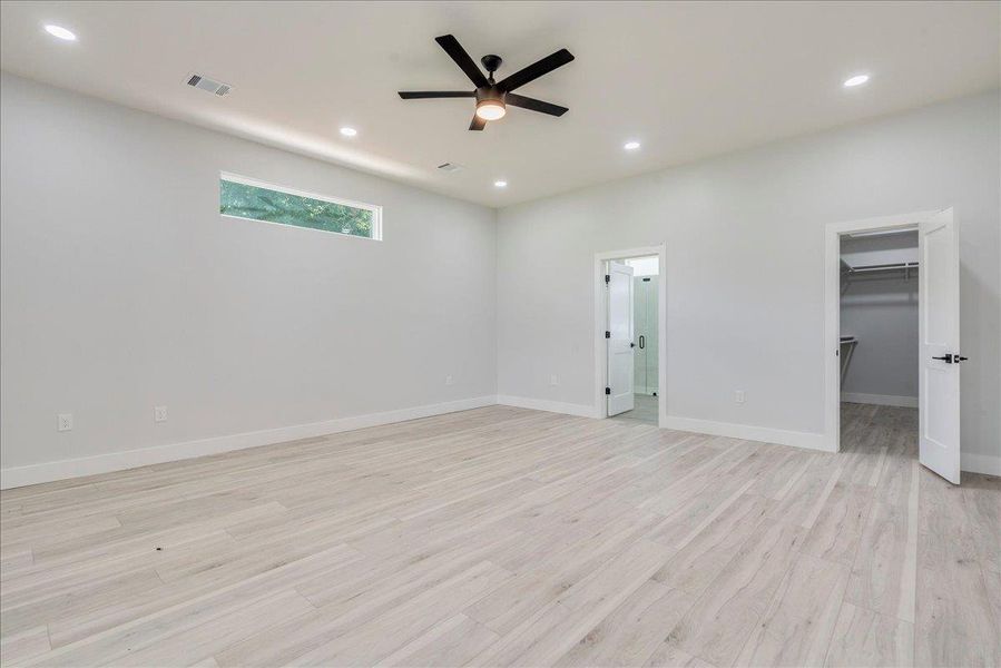 Unfurnished bedroom with light wood-style floors, recessed lighting, a walk in closet, and a ceiling fan