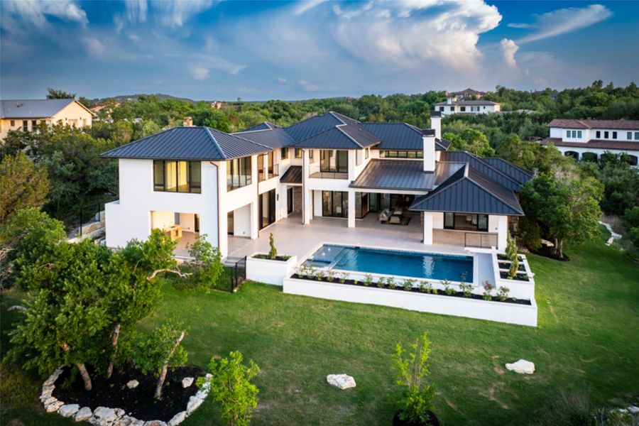 The property features a contemporary architectural style with a dark metal roof and white exterior