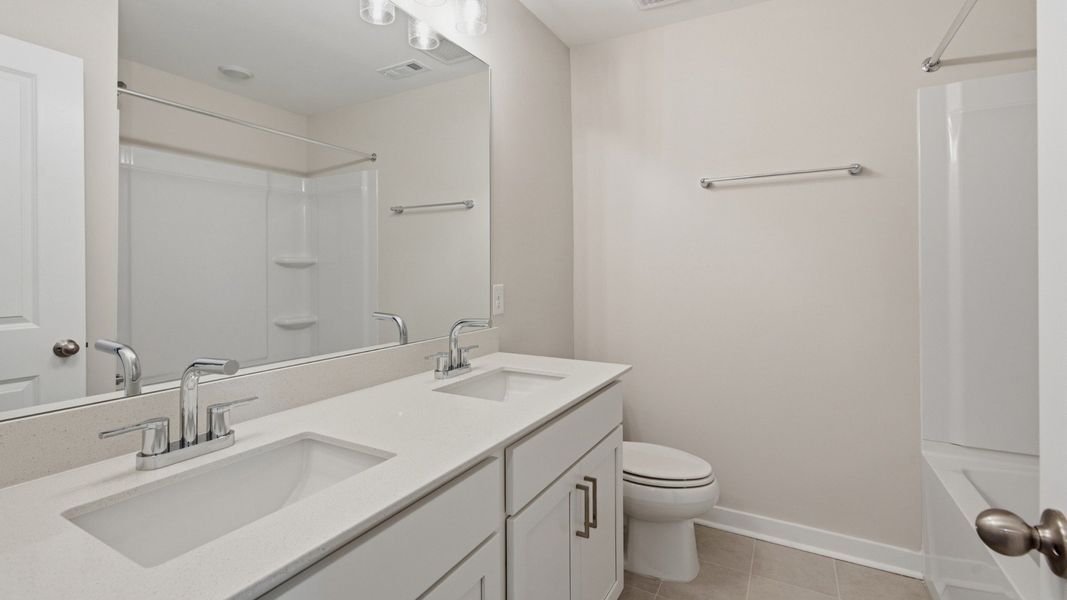 Bathroom with dual vanities across bathtub and shower