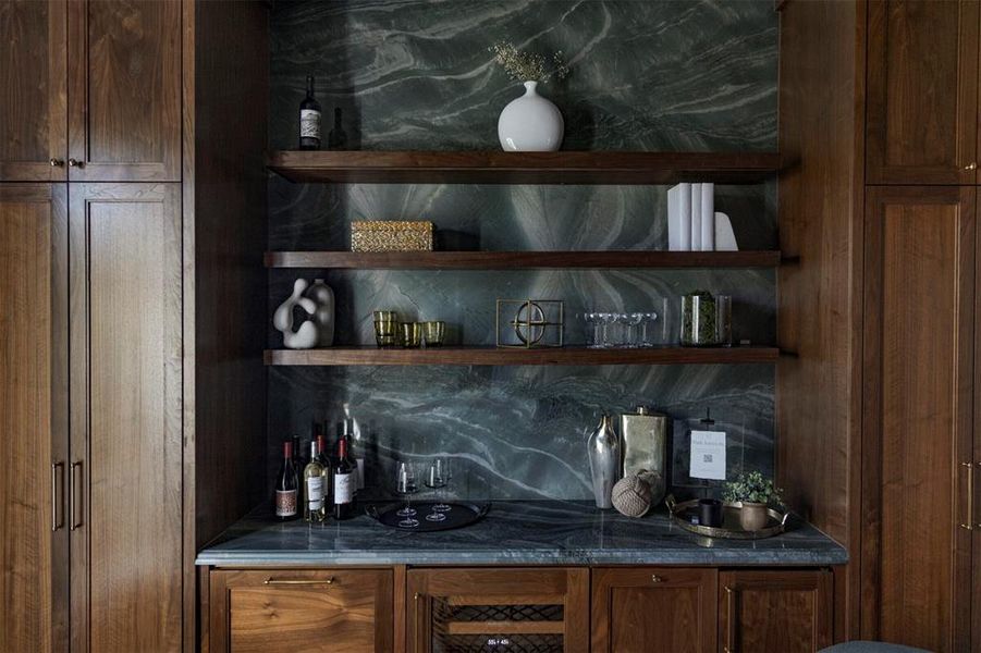 Indoor bar with open shelves, dark stone countertops, decorative backsplash, and brown cabinets Indoor bar with open shelves, dark stone countertops, decorative backsplash, and brown cabinets