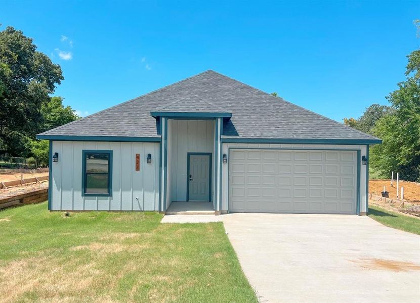 View of front facade with a garage and a front lawn