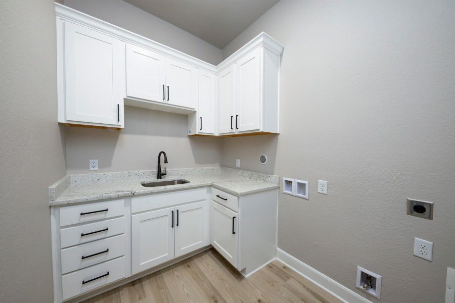 The laundry room in this home makes you want to do laundry. Upper and lower cabinets with a built in sink provide stylish storage. The laundry room in this home makes you want to do laundry. Upper and lower cabinets with a built in sink provide stylish storage.