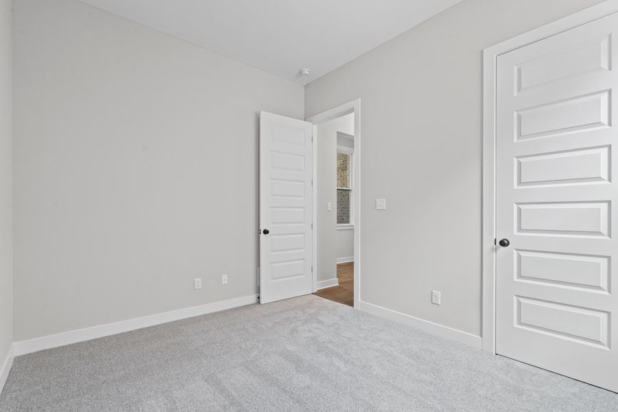 Unfurnished bedroom with baseboards and carpet Unfurnished bedroom with baseboards and carpet