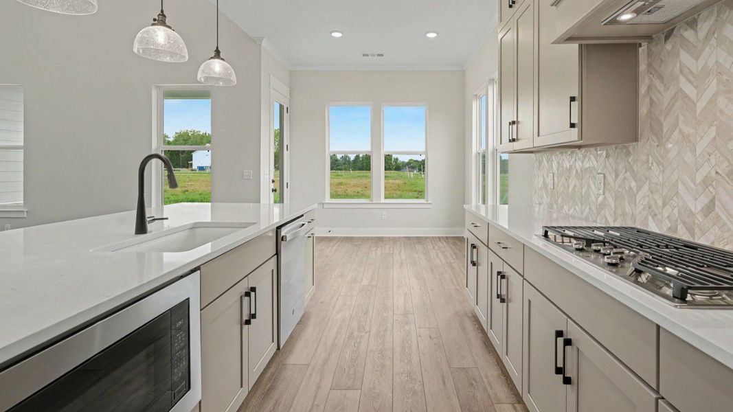 Kitchen with quartz countertops, pendant lighting, and tile backsplash