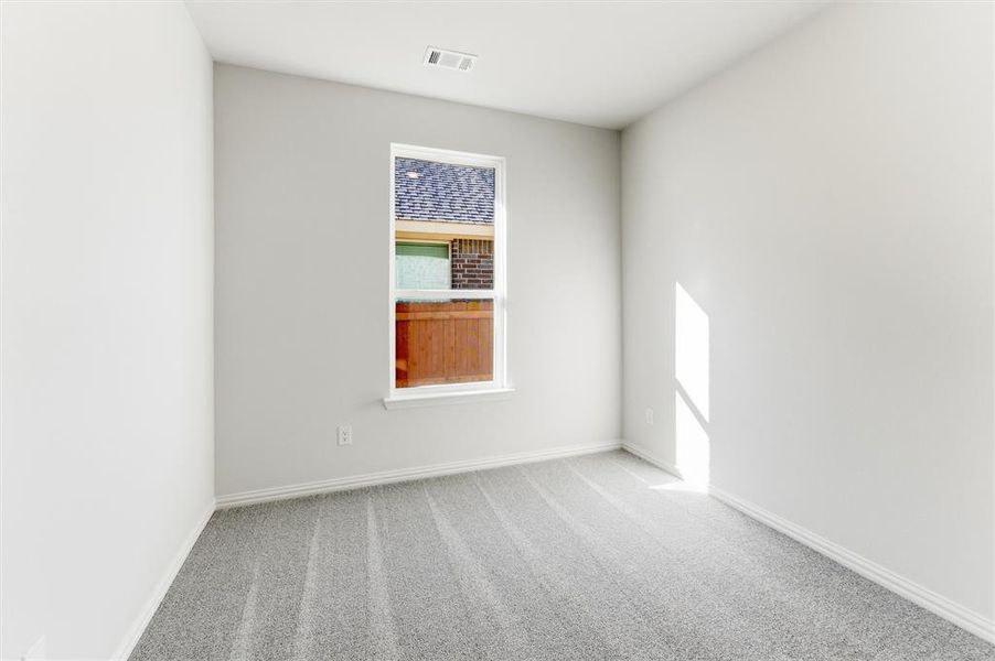 Carpeted spare room with baseboards