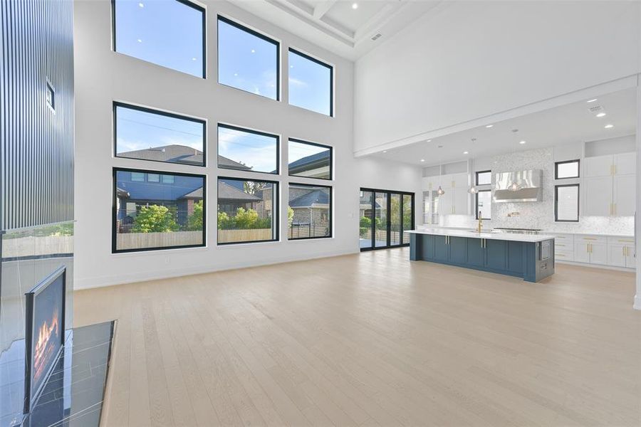 This picture highlights the open nature of the living area, flowing seamlessly into the kitchen. the large sliding doors access the outside covered living area which overlooks the large backyard with room for a pool.