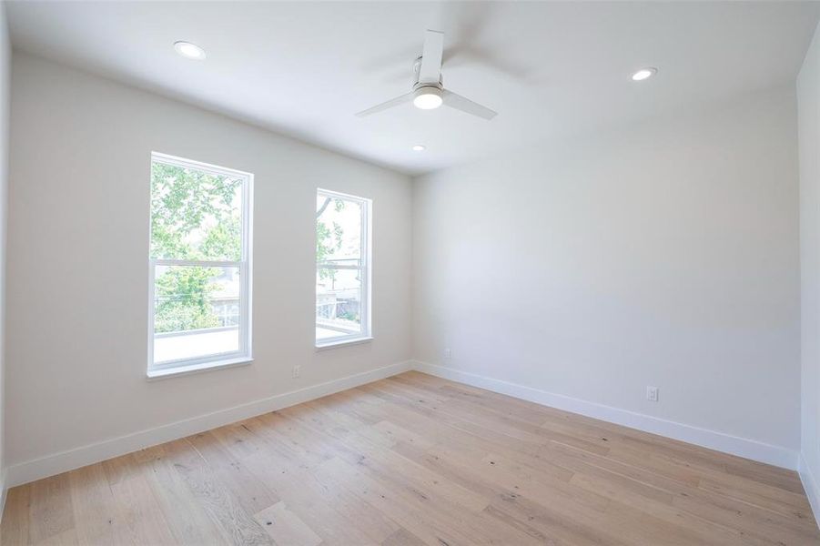 Empty room with ceiling fan and light hardwood / wood-style floors Empty room with ceiling fan and light hardwood / wood-style floors