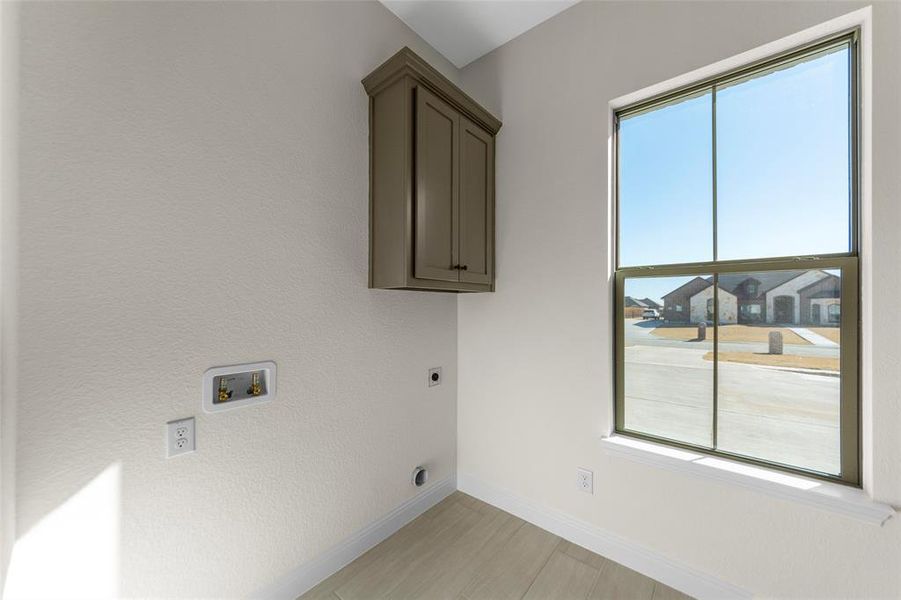 Laundry area with cabinet space, washer hookup, and hookup for an electric dryer Laundry area with cabinet space, washer hookup, and hookup for an electric dryer