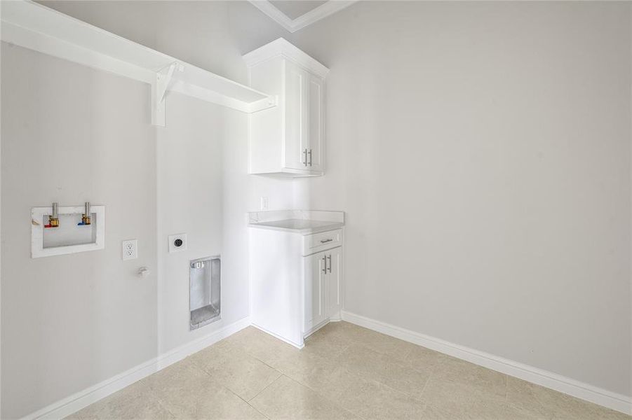 Laundry room with washer hookup, hookup for an electric dryer, hookup for a gas dryer, ornamental molding, and light tile patterned flooring