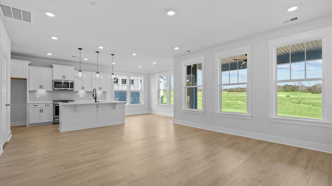 Elegant family room featuring hardwood flooring, large windows, and thoughtful architectural detail