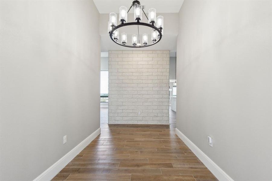 Entry with baseboards, wood look tile floors, and a chandelier Entry with baseboards, wood look tile floors, and a chandelier