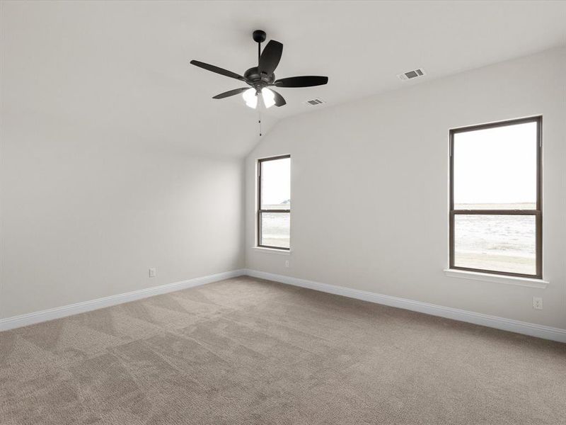 Spare room featuring lofted ceiling, light carpet, and ceiling fan