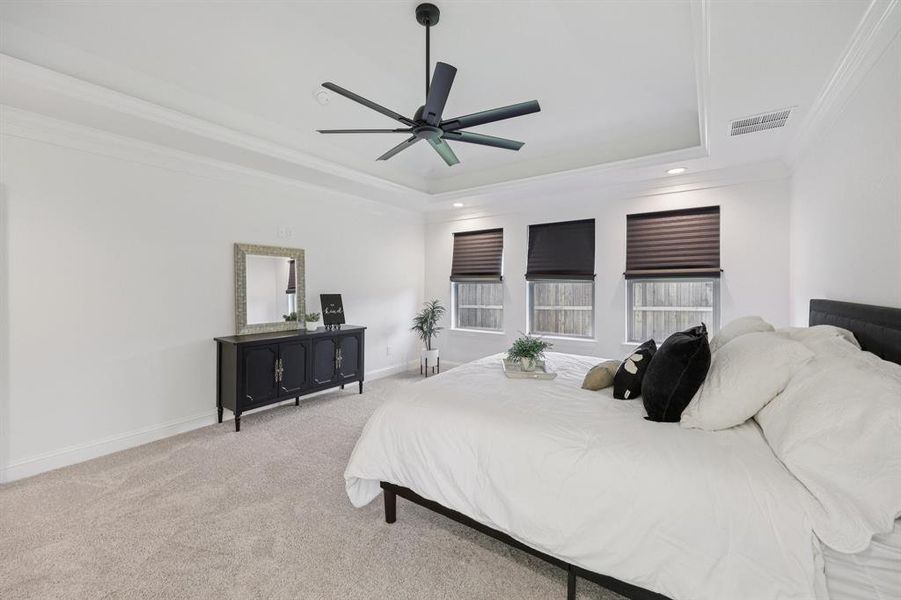 Bedroom with ornamental molding, light carpet, ceiling fan, a tray ceiling, and recessed lighting Bedroom with ornamental molding, light carpet, ceiling fan, a tray ceiling, and recessed lighting