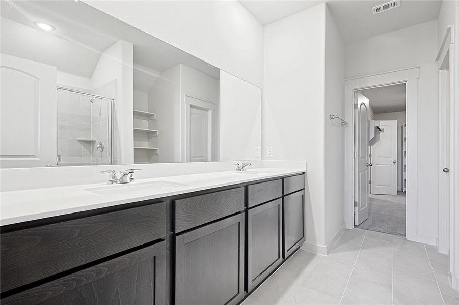 Bathroom with tile patterned flooring, vanity, and a shower with shower door