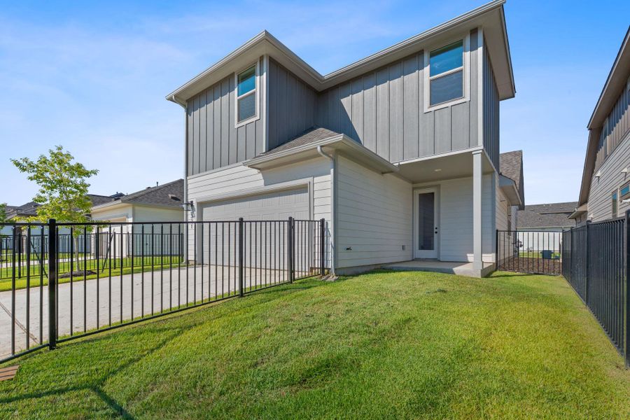 Rear view of property featuring board and batten siding, a patio area, a garage, and concrete driveway Rear view of property featuring board and batten siding, a patio area, a garage, and concrete driveway