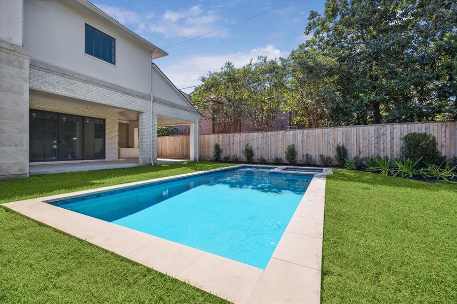 A covered porch overlooks pool and spa. Outdoor kitchen and pool bath are another feature of this beautiful home.